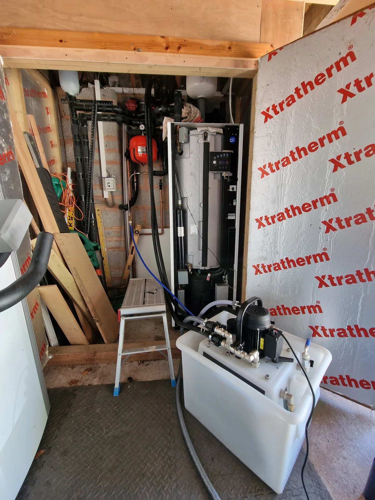 Flush pump connected inside the plant room next to one of the ground source heat pumps