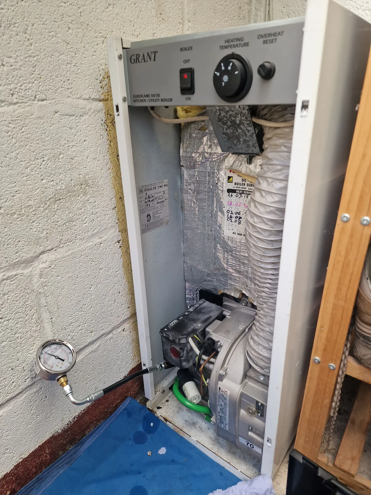 GRANT oil boiler open for repair with pressure gauge in use