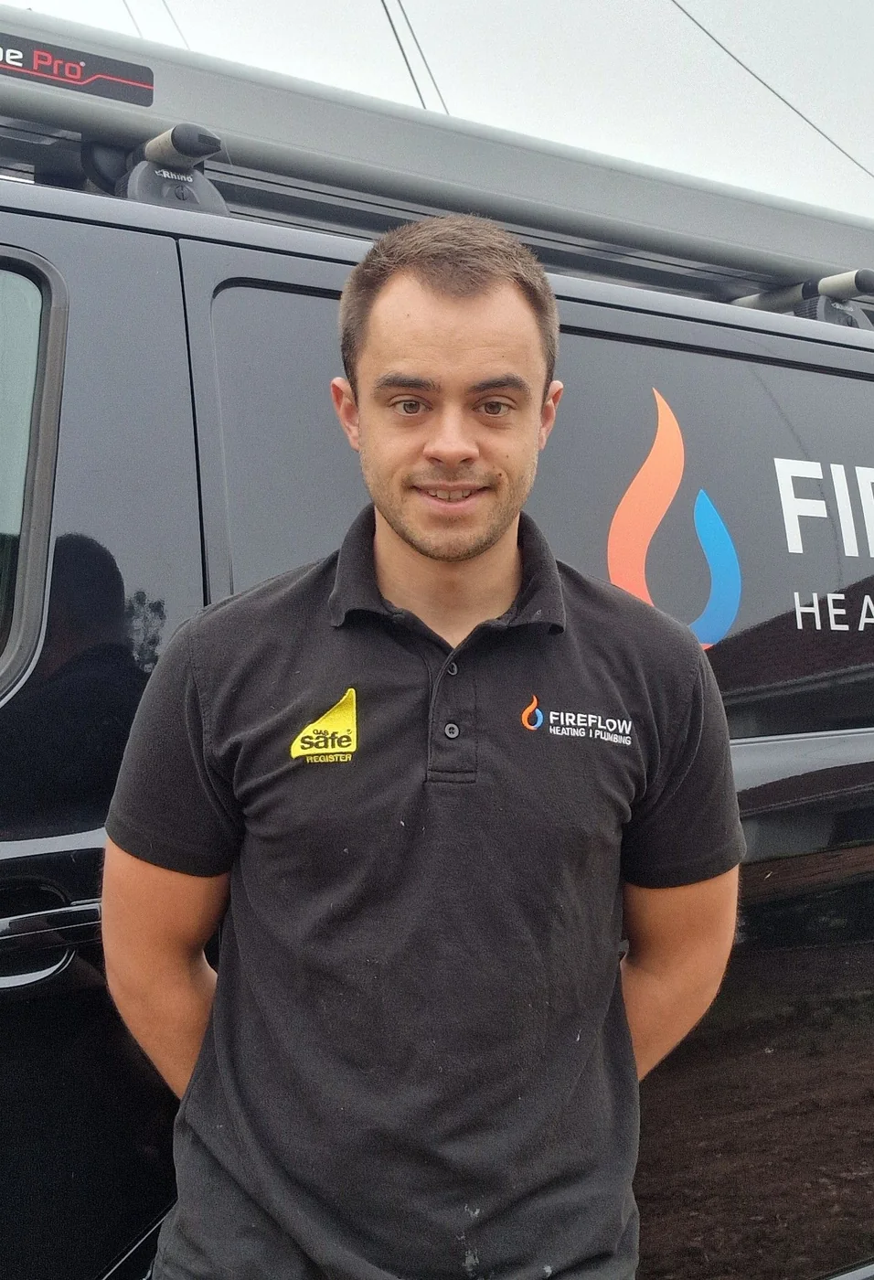 Bradley Harrison, Gas Safe registered engineer and founder of FireFlow Heating & Cooling, in front of his signwritten van
